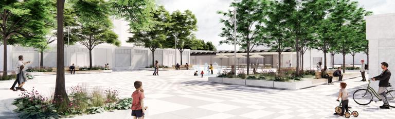 Zu sehen sind Menschen, die auf einem begrünten Platz mit Schatten sitzen.